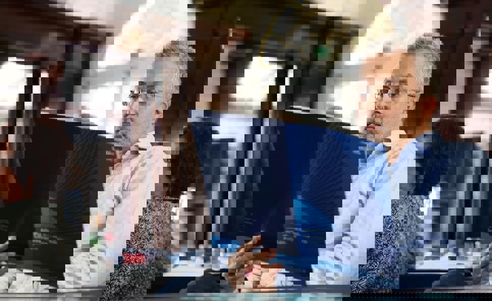 A man sat at a table in BMA House reading a BMA agenda on public health