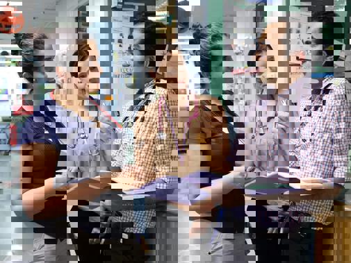 Three doctors in discussion on ward.