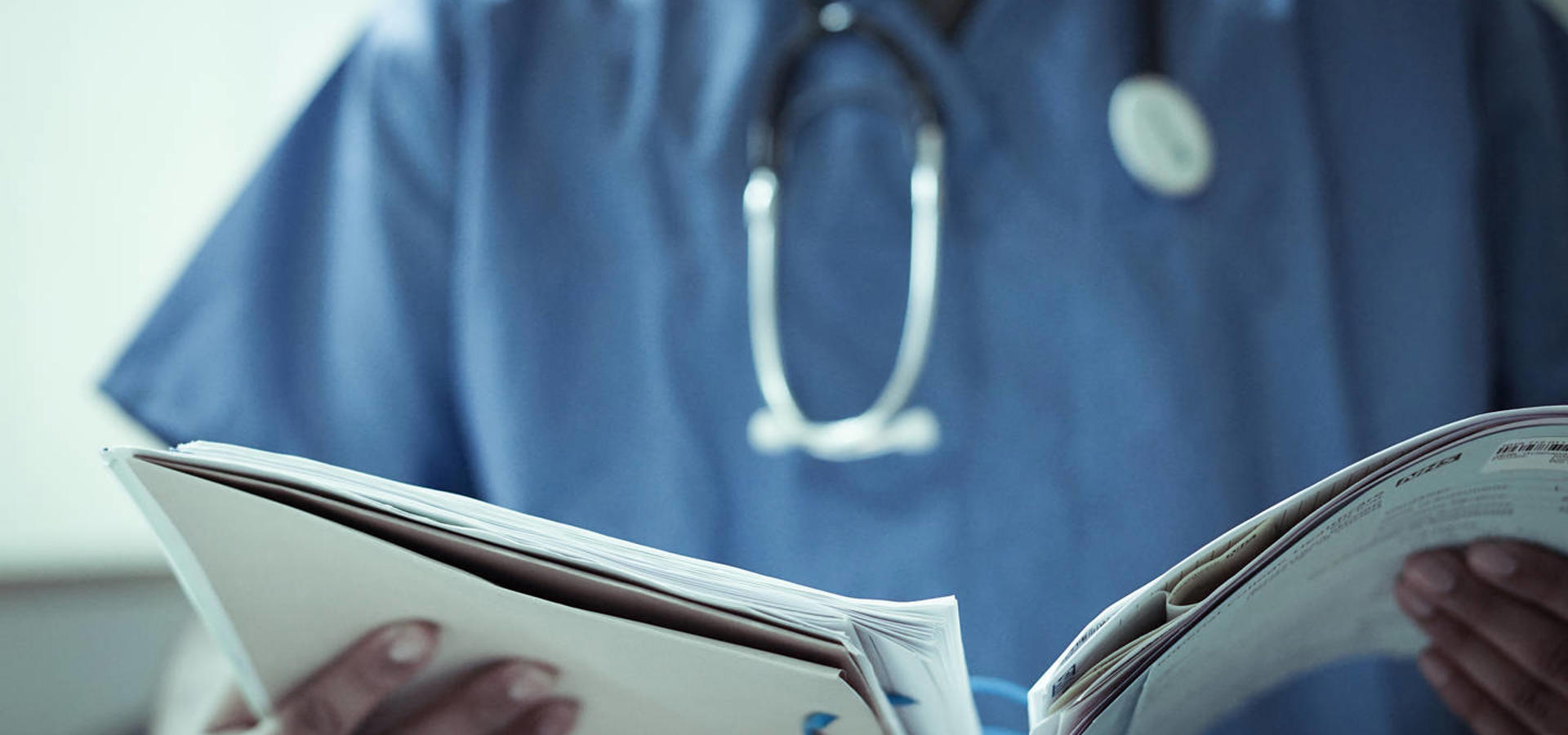 Doctor in scrubs reviewing patient file