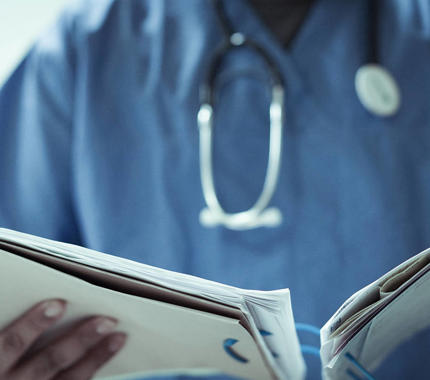Doctor in scrubs reviewing patient file