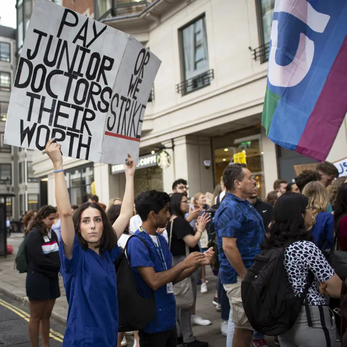 Protestors holding banner saying 'Pay junior doctors their worth'